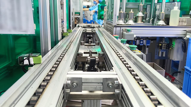 工場の自動化ラインの内部、機械とレールが並ぶ工場の生産ラインの写真.